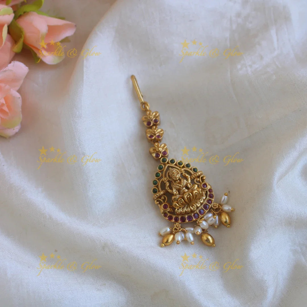 Gold alike Lakshmi carved maang tikka with ruby emerald and rice pearl drops - Sparkle and Glow