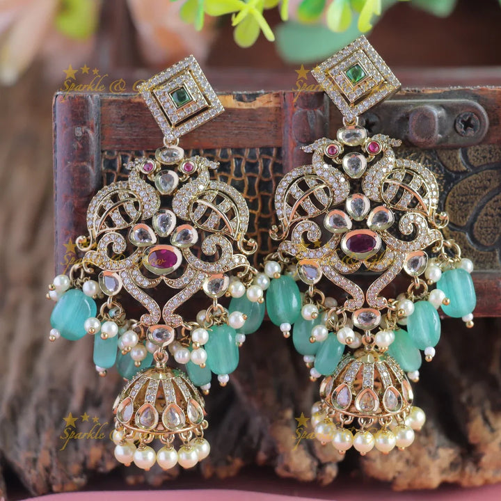 Gracious Dual tone Peacock carved Victorian AD earrings with jhumuka hanging - Sparkle and Glow