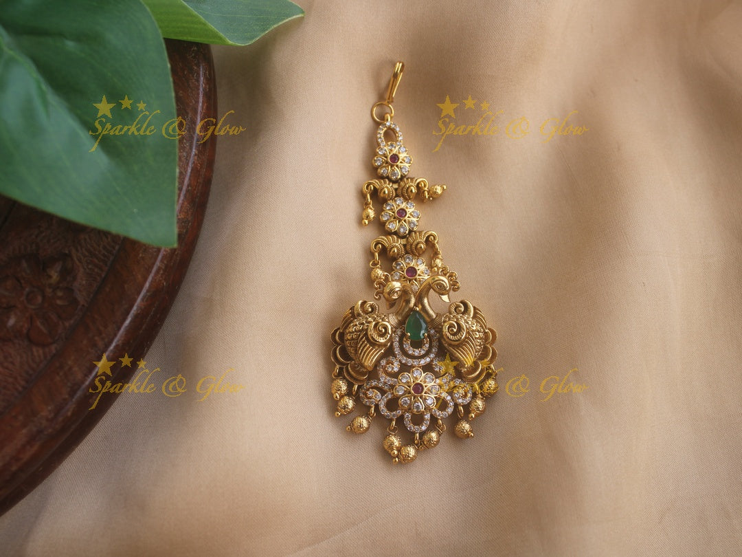 Beautiful Gold alike Peacock carved maang tikka with cz stones emerald and gold beads
