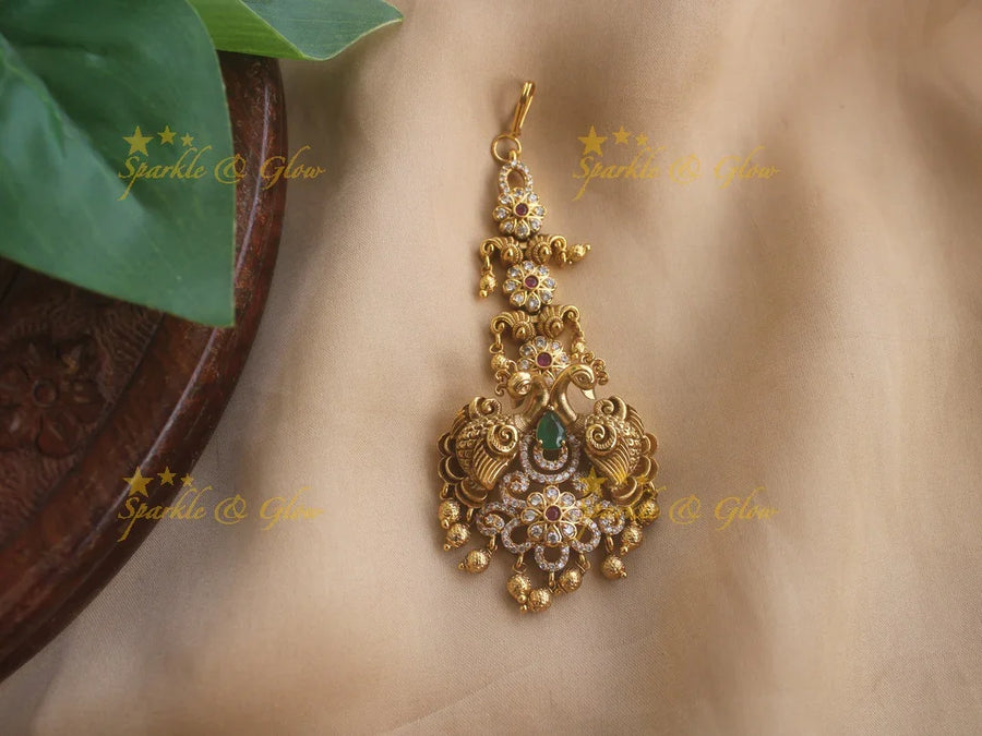 Beautiful Gold alike Peacock carved maang tikka with cz stones emerald and gold beads - Sparkle and Glow