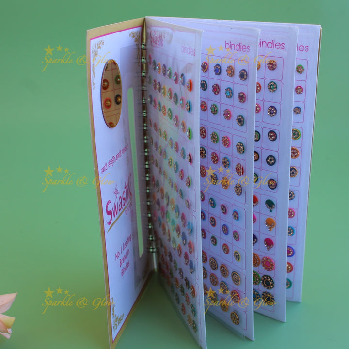 Swastik stone bindi with different shape and size in spiral book in assorted colours