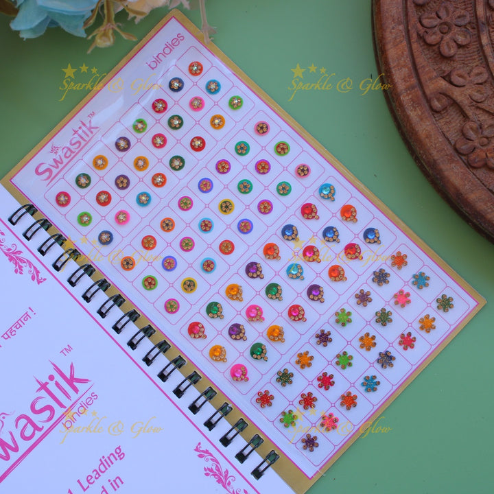 Swastik stone bindi with different shape and size in spiral book in assorted colours