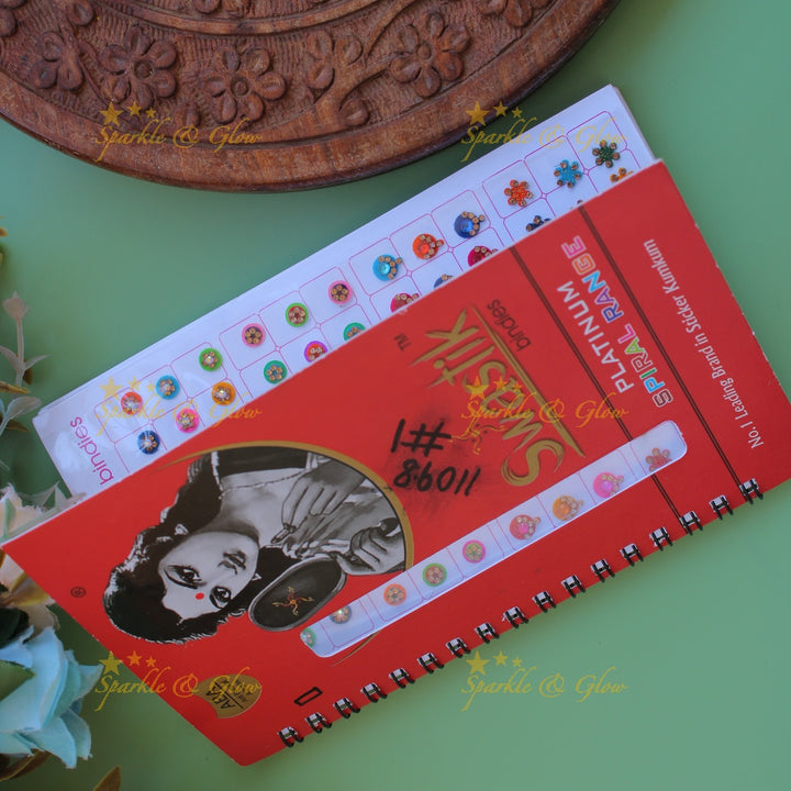Swastik stone bindi with different shape and size in spiral book in assorted colours
