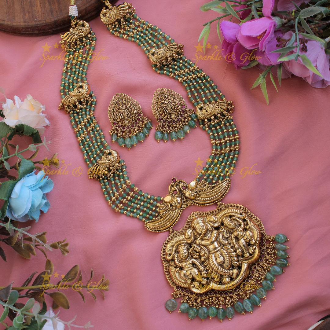 Gorgeous Krishna playing flute and peacock carved haram with multi layer gold and red beads chain