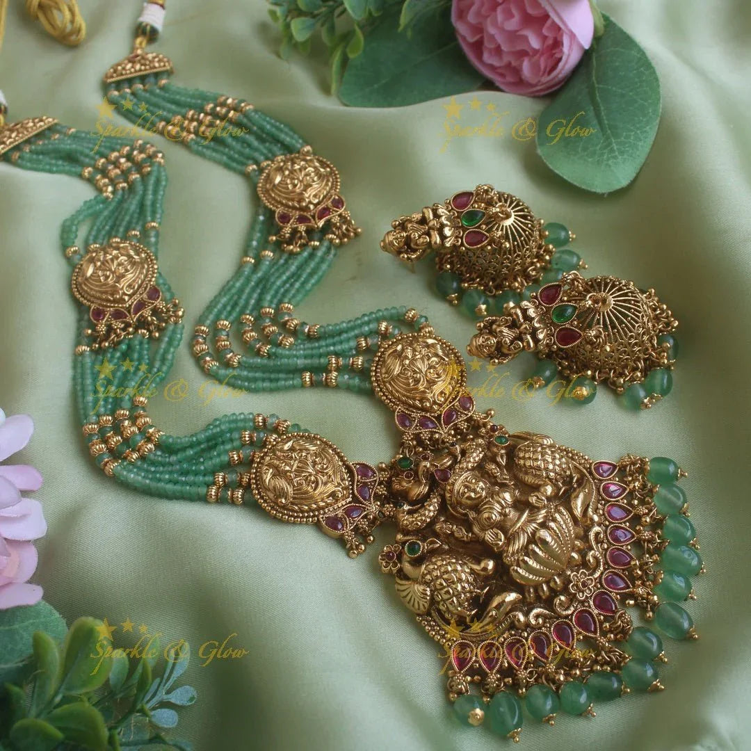 Exclusive Lakshmi peacock carved pendant haram with multi layer gold and mint green beads chain and ruby stones - Sparkle and Glow