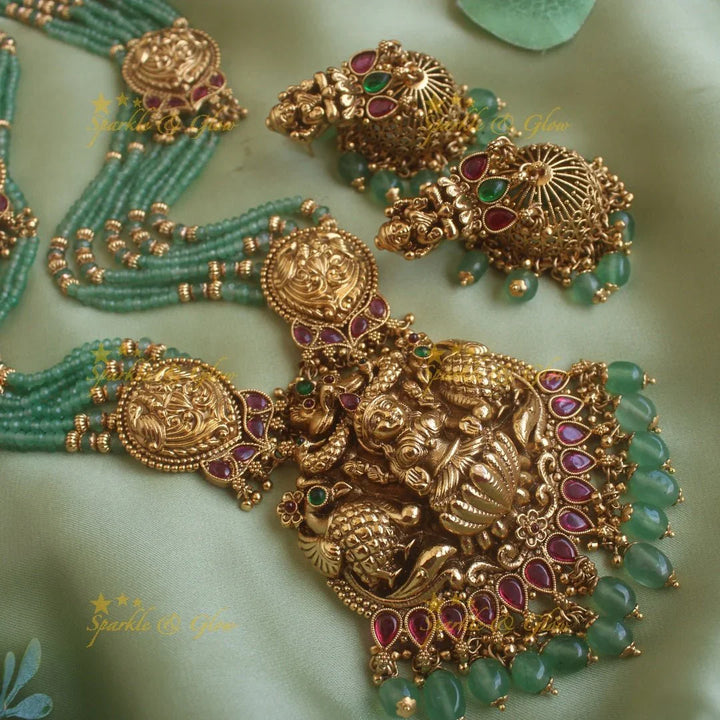 Exclusive Lakshmi peacock carved pendant haram with multi layer gold and mint green beads chain and ruby stones - Sparkle and Glow