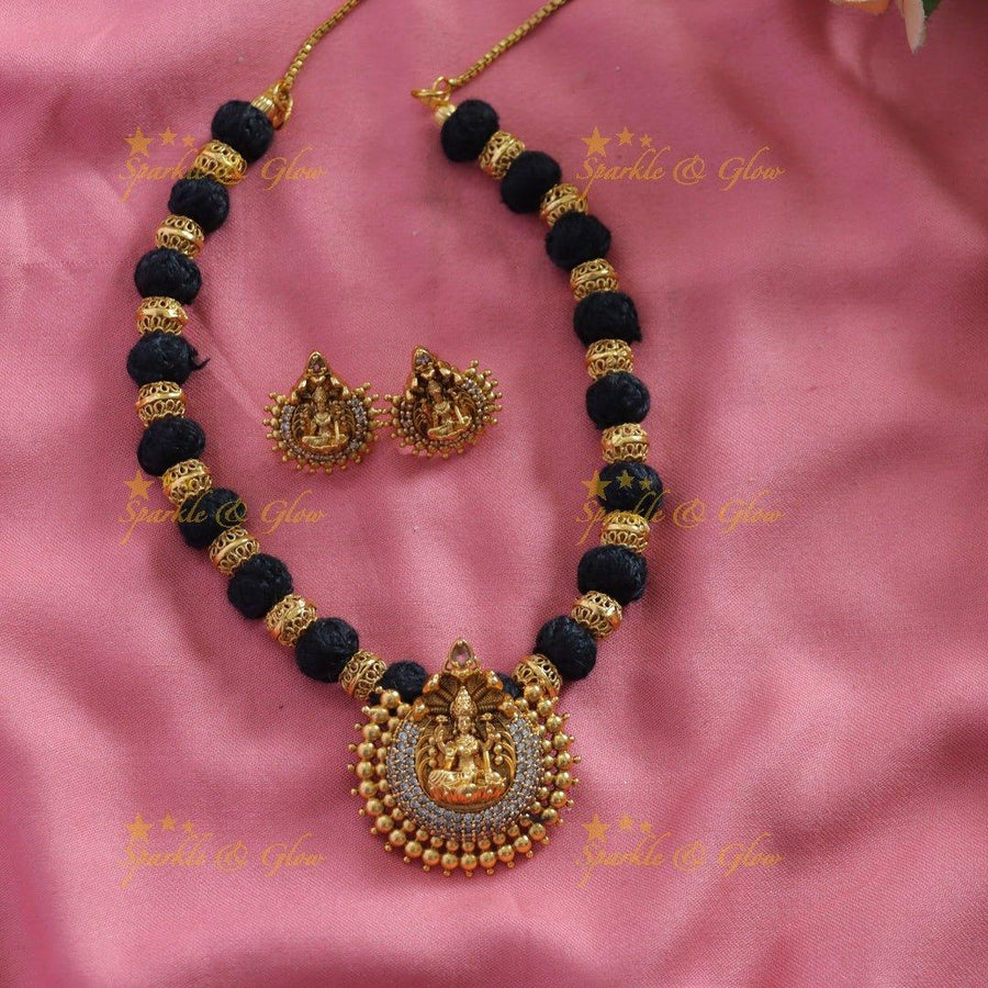 Statement Lakshmi carved pendant black thread short necklace with gold beads and blue stones - Sparkle and Glow