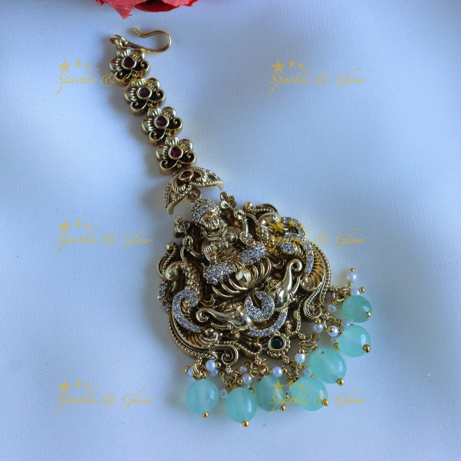 Elgant Idol Lakshmi peacock carved Floral Maangtikka with mintgreen beads - Sparkle and Glow - 