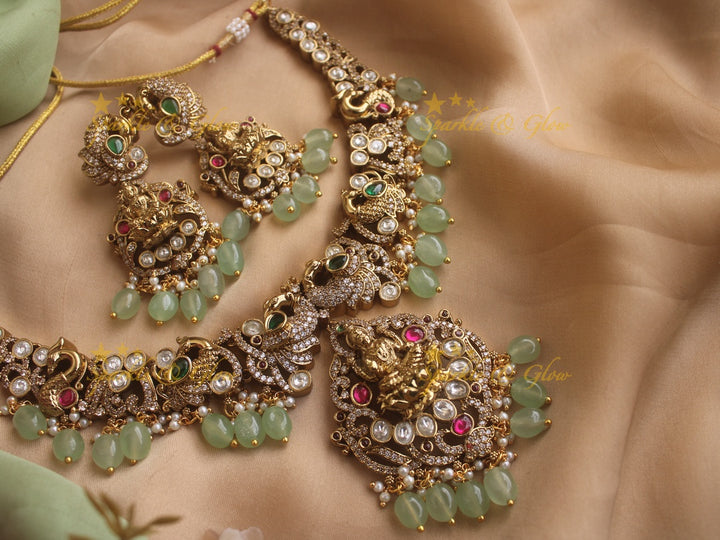 Exquisite Lakshmi and Peacock Victorian Gold finish AD necklace with ruby emerald pastel green beads