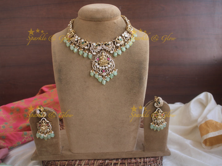 Exquisite Lakshmi and Peacock Victorian Gold finish AD necklace with ruby emerald pastel green beads